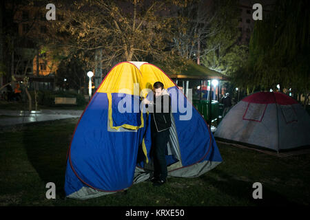 Teheran, Iran. 21 Dez, 2017. Ein Mann wird ein Zelt an einem Park nach dem Erdbeben in Teheran, Iran, Dez. 21, 2017. Ein Erdbeben der Magnitude 5,2 auf der Richterskala hat in der Malard Stadt in der iranischen Provinz Teheran am Mittwoch um 23:27 Ortszeit (1957 GMT), der Iran seismologischen Center (ISC) sagte. Credit: Ahmad Halabisaz/Xinhua/Alamy leben Nachrichten Stockfoto