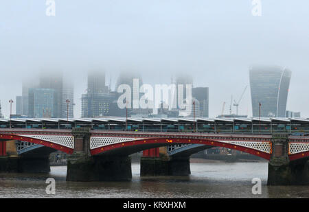 London, Großbritannien. 21 Dez, 2017. Blackfriars Station über die Themse in London auf einem Nebelhaften und nebligen, verregneten Morgen mit dem Walkie talkie und das Bürogebäude der Stadt London mit ihren Spitzen in den niedrigen Wolkenuntergrenze. Wolken und trüben, regnerischen Wetter über die Stadt London und die Themse. Quelle: Steve Hawkins Fotografie/Alamy leben Nachrichten Stockfoto