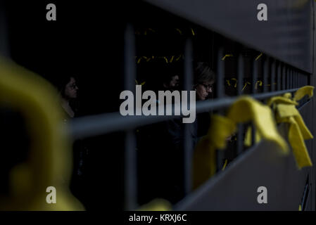 Barcelona, Spanien. 21 Dez, 2017. Bewohner gesehen hängen gelbe Band in der Nähe der Wahllokale für die Katalonien Landtagswahl. Katalanisch begann heute eine neue Regierung zu wählen, mit zwei Wahl, ein Pro zu werden - Unabhängigkeit der Parteien oder der Region als Teil Spaniens zu halten. Credit: SOPA/ZUMA Draht/Alamy leben Nachrichten Stockfoto