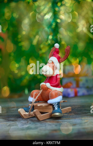 Weihnachten Elch in Kleidung auf hölzernen Schlitten Stockfoto