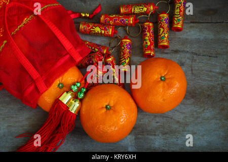 Orangen mit roten Lucky Beutel und Feuerwerkskörper vorbereitet für ein Chinesisches Neues Jahr Stockfoto