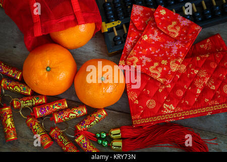 Orangen mit roten Lucky Beutel und Feuerwerkskörper vorbereitet für ein Chinesisches Neues Jahr Stockfoto