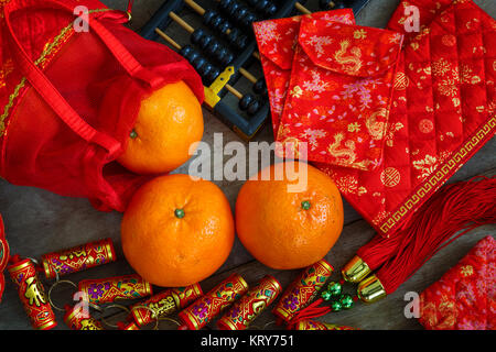 Orangen mit roten Lucky Beutel und Feuerwerkskörper vorbereitet für ein Chinesisches Neues Jahr Stockfoto