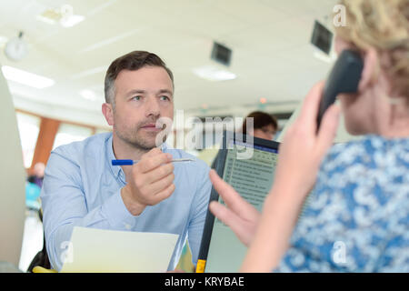 Aufnahme eines jungen Geschäftsmann im Gespräch mit Kollegin Stockfoto