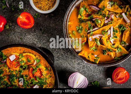 Indische Küche Rezepte, Masala Omelett Omelett mit und indische Masala Ei Curry, mit frischem Gemüse - Tomate, hot chili Pfeffer, Petersilie dunklen Stein bac Stockfoto