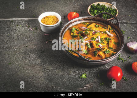 Indische Küche Rezepte, indische Omelett Masala Ei Curry, mit frischem Gemüse - Tomate, hot chili Pfeffer, Petersilie dunklen Stein Hintergrund Kopie Raum Stockfoto