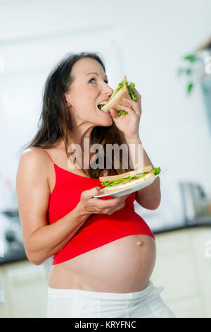 Schwangere Frau isst ein Sandwich - schwangere Frau isst ein Sandwich Stockfoto