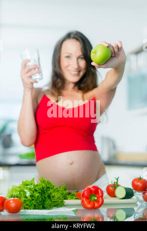 Schwangere Frau ernährt sich gesund - schwangere Frau mit Wasser und einen Apfel Stockfoto