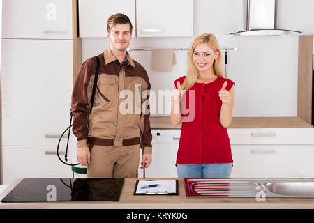 Portrait von Frau und Schädlingsbekämpfung Arbeitnehmer in der Küche Stockfoto