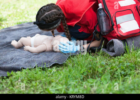 Sanitäter der Herz-Lungen-Wiederbelebung (HLW) auf Baby dummy demonstrieren Stockfoto