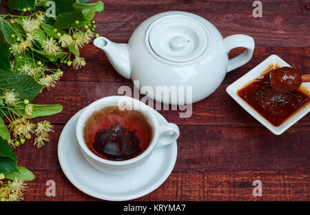 Weiße Tasse heißer schwarzer Tee, Teekanne und Honig von Linde Stockfoto