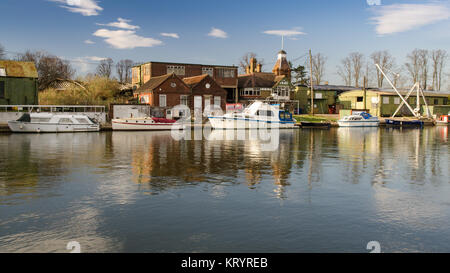 London, England, UK - 15. März 2014: Sportboote sind in der Themse an einem sonnigen Tag neben dem verfallenden Bootswerft Gebäude und Studios günstig Stockfoto