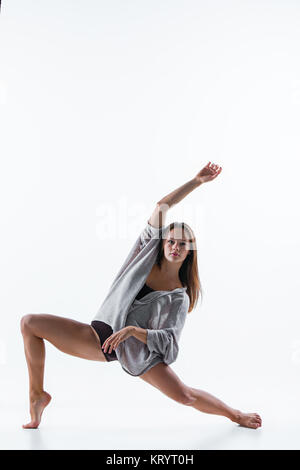 Junge schöne Tänzerin in beige Kleid tanzen auf weißem Hintergrund Stockfoto