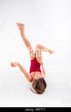 Junge schöne Tänzerin in beige Kleid tanzen auf weißem Hintergrund Stockfoto
