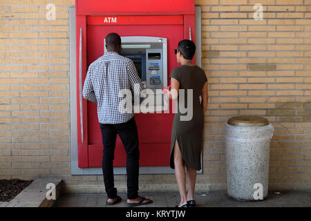 Männliche Personen mit Rückansicht heben Bargeld an einem Geldautomaten der US Bank of America ab, bei einem Gebäude in Los Angeles, LA California, USA KATHY DEWITT Stockfoto