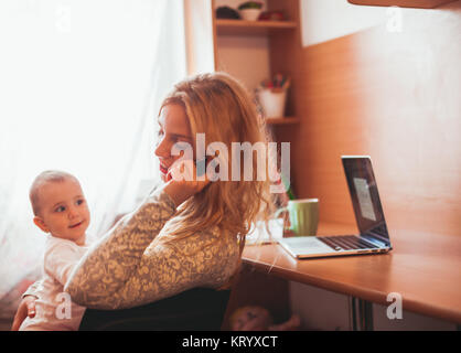 Freiberuflich arbeitete Mama mit baby Stockfoto