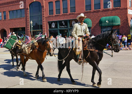 Cody, Wyoming, USA - Juli 4., 2009 - Mitglied des US Forest Service auf seinem Pferd führenden mehrere Packpferden in der Independence Day Parade montiert Stockfoto