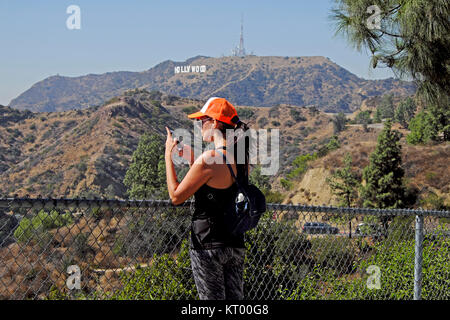 Eine Frau touristische trägt einen Baseball Cap eine selfie mit ipod Telefon und Hollywood Sign in Griffith Park, Los Angeles, Kalifornien USA KATHY DEWITT Stockfoto