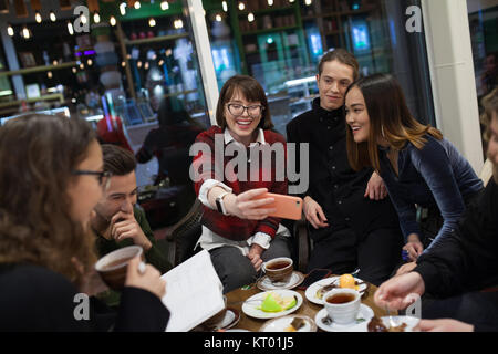 Machen Gruppe positiver Jugendliche selfies und die Zeit in einem Cafe. Stockfoto