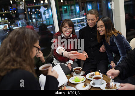 Machen Gruppe positiver Jugendliche selfies und die Zeit in einem Cafe. Stockfoto