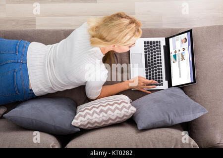 Frau mit Social Networking Website auf Laptop Stockfoto