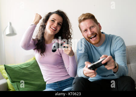 Glückliches Paar Videospiele spielen zu Hause Stockfoto