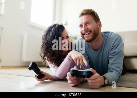 Glückliches Paar Videospiele spielen zu Hause Stockfoto