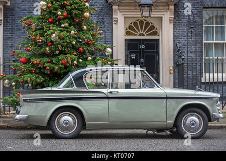 Larry die Katze spaziergänge underneathGreg Knight's MP 1961 Sunbeam Rapier Auto, nachdem es in der Downing Street in London eintrifft. Stockfoto