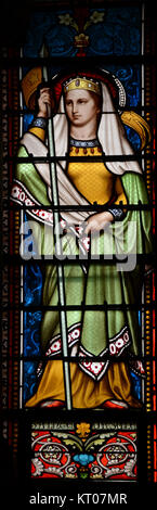 Das Buntglas in der Basilique in Ars-sur-Formans, Frankreich, zeigt eine Darstellung von Sainte Ursule. Das am 21. Oktober 2015 fotografierte Werk unterstreicht die künstlerische und religiöse Bedeutung des Innenraums der Basilika. Stockfoto