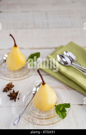 Weißwein und Gewürzen pochierte Birnen. Stockfoto