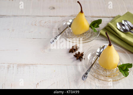 Weißwein und Gewürzen pochierte Birnen. Stockfoto