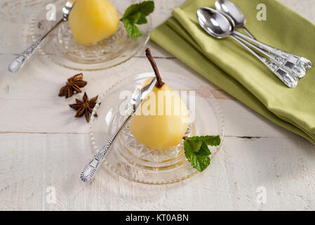 Weißwein und Gewürzen pochierte Birnen. Stockfoto