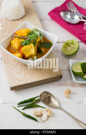 Kabeljau und Baby mais Kokos Curry auf einem rustikalen weißer Tisch. Stockfoto