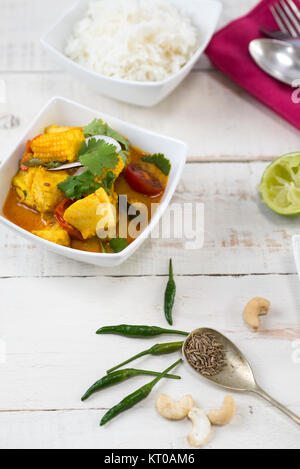 Kabeljau und Baby mais Kokos Curry auf einem rustikalen weißer Tisch. Stockfoto