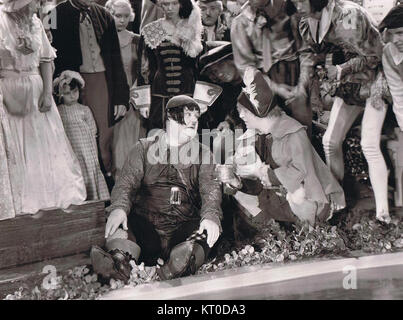 Diese Publicity aus dem Film *Babes in Toyland* aus dem Jahr 1934 zeigt Szenen aus dem skurrilen und farbenfrohen Film. Der Film basiert auf der Operette von Victor Herbert und zeigt eine Fantasy-Welt mit Figuren wie Mutter Gans und der Spielzeughersteller. Stockfoto