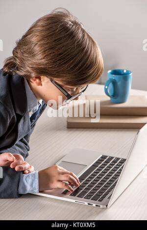 Schulkind im Geschäft mit laptop computer Anzug Stockfoto