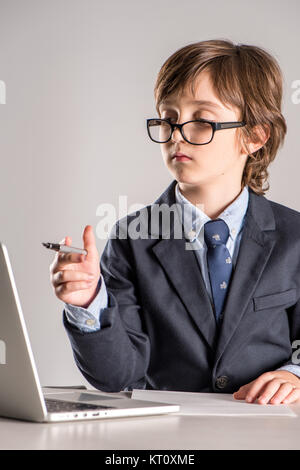 Schulkind in Anzug mit Stift in der Hand Stockfoto