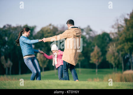 Glückliche Familie Hand in Hand auf Wiese Stockfoto