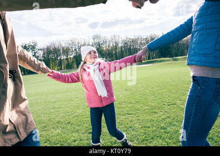 Glückliche Familie Hand in Hand auf Wiese Stockfoto