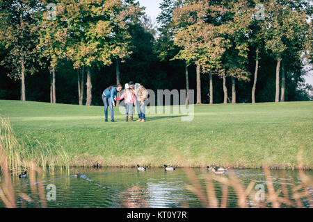 Glückliche Familie mit Blick auf Enten im park Stockfoto