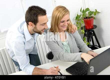 Attraktiver Mann und Frau mit Laptop Stockfoto