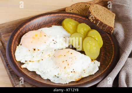 Spiegeleier mit marinierten Gurken und Roggenbrot. Stockfoto