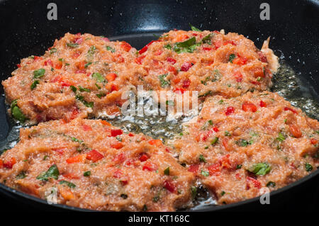 hausgemachte Frikadellen mit Gemüse in der Pfanne auf Keramik Herd kochen Stockfoto