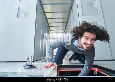 Junger Mann etwas zur Festsetzung in die bodenluke. Data Center. Server Stockfoto