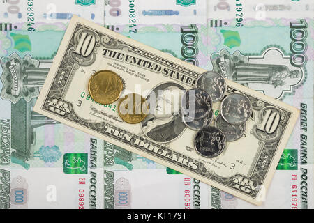 Münzen Rubel und der Euro sind auf der Rechnung von zehn Dollar liegt an einem Haufen von tausend-russische Banknoten Stockfoto