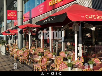 Außenansicht des Café Rouge Restaurant mit roten Schirmen und außerhalb von Tabellen an einem sonnigen Tag in St. Katharine Docks London England United Kingdom UK Stockfoto