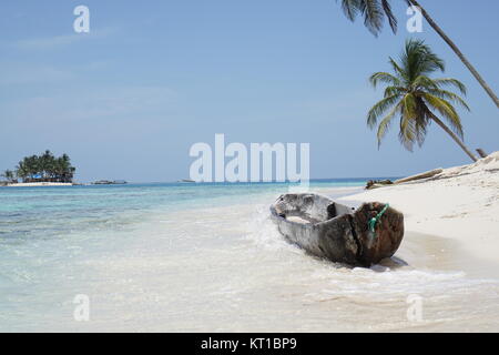 Kleines holzboot am traumhaften Strand mit klarem, blauen Wasser der Karibik auf der San Blas Inseln, Panama Stockfoto