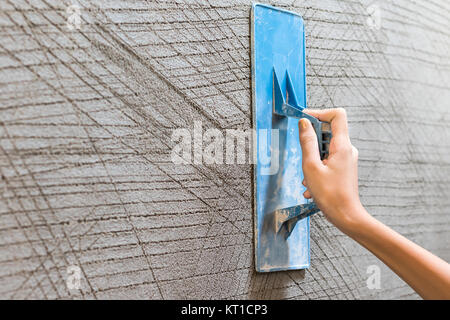 Arbeitnehmer putz Beton Wand Stockfoto