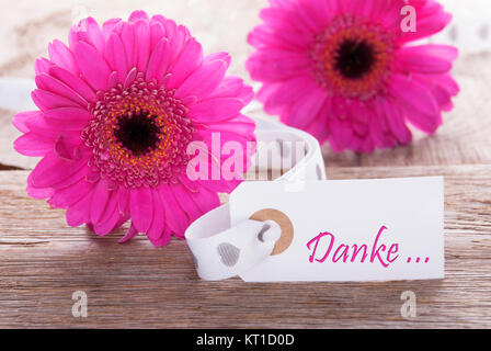 Etikett mit deutschem Text Danke, Danke. Rosa Frühling Gerbera Blume. Jahrgang, Rutic oder Alter Holz- Hintergrund. Karte für Frühjahr Grüße. Stockfoto