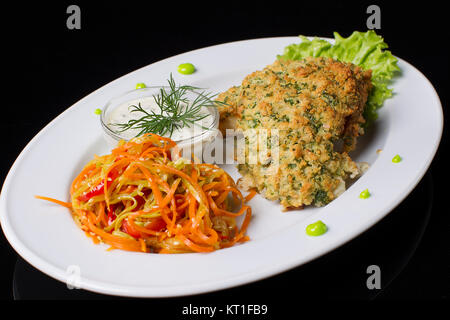 Gebratenes Fleisch in Paniermehl mit gedünsteten Karotten und Soße. Essen in einer Platte. Fleisch in Panade. Stockfoto